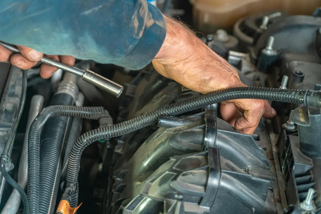 Professional auto mechanic working on a car engine at Bani Auto Repair 24/7 service shop in Manhattan